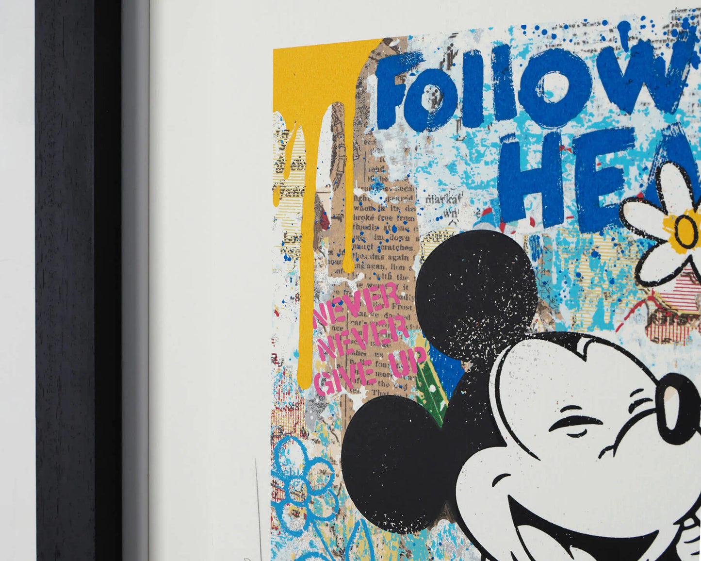 A detailed view of the black contemporary frame and white mount for the "Forever Starts Here" artwork. The image showcases the high-quality finish and official studio stamps from the Disney x Mr. Brainwash global collaboration.