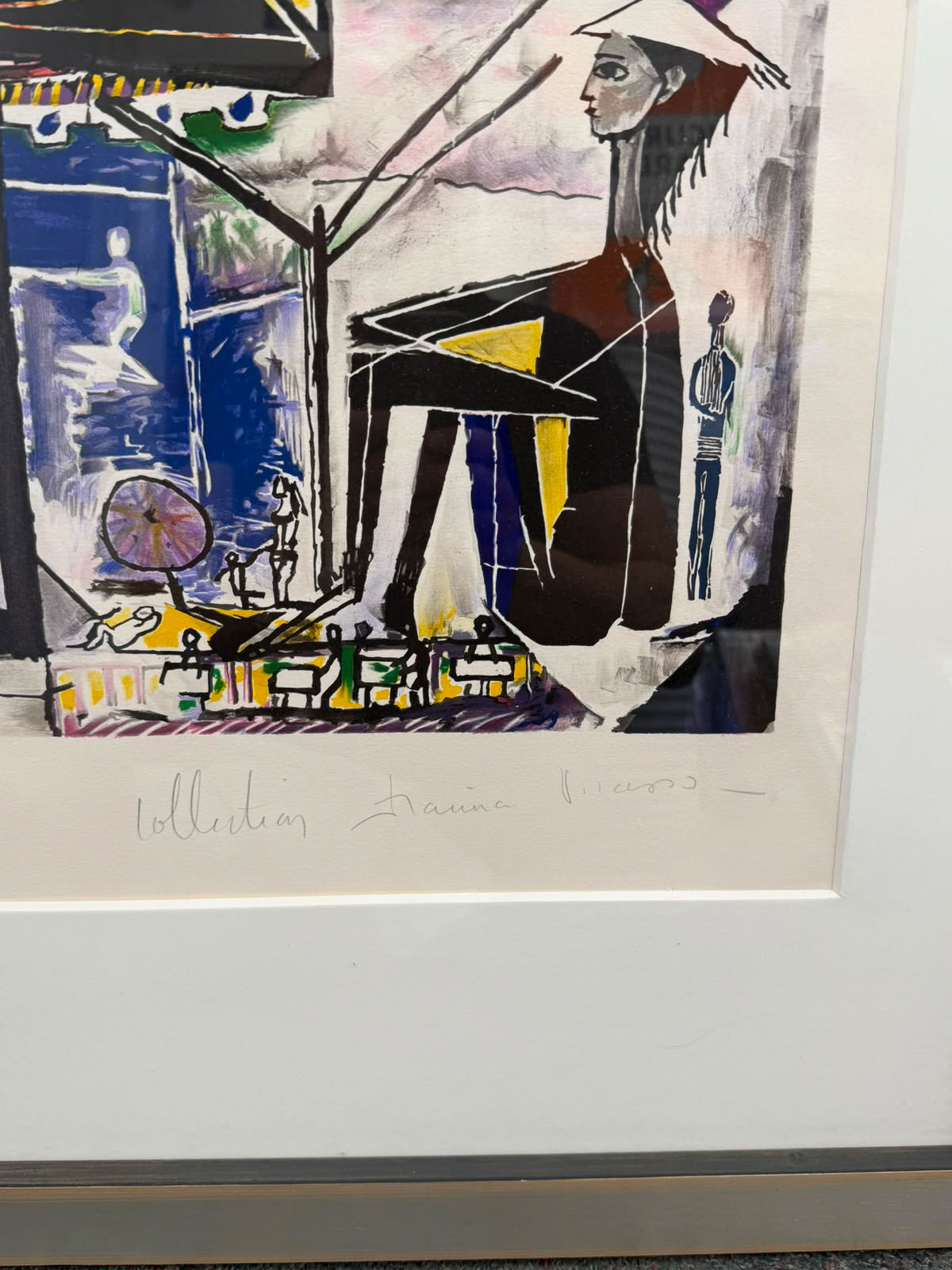 A framed abstract art print featuring a stylized seated figure with bold black, blue, yellow, white, and purple brushstrokes, shown with a wide white mat and handwritten signature below.