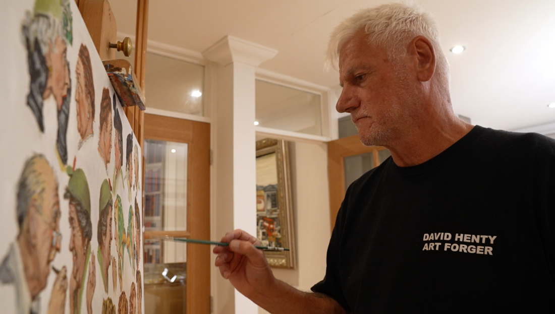 David Henty at work in his studio, adding fine detail to a canvas wearing his signature David Henty Art Forger t-shirt