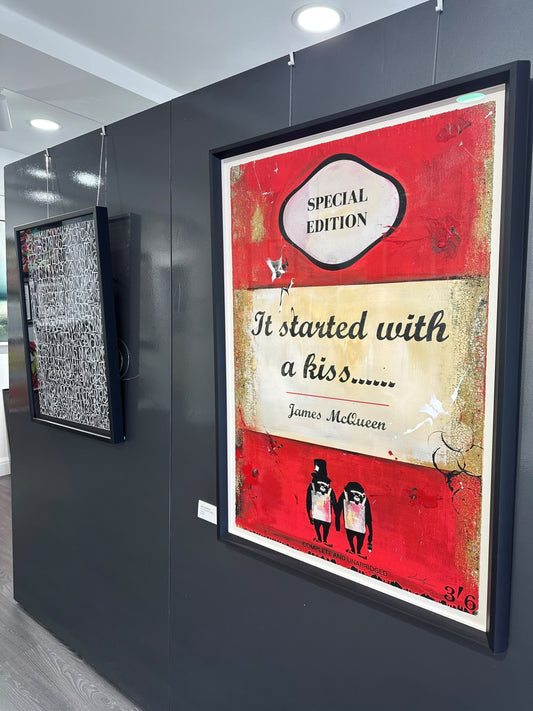 Installation view inside Creed Gallery Ascot, showing James McQueen's 'It Started with a Kiss' hanging on a dark gallery wall under professional spot lighting.