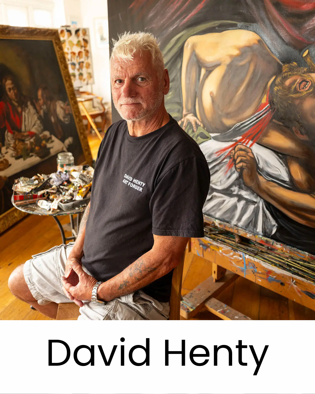 _David_Henty.pngDavid Henty photographed in his studio wearing his Art Forger t-shirt, surrounded by works in progress including a large Caravaggio homage on canvas