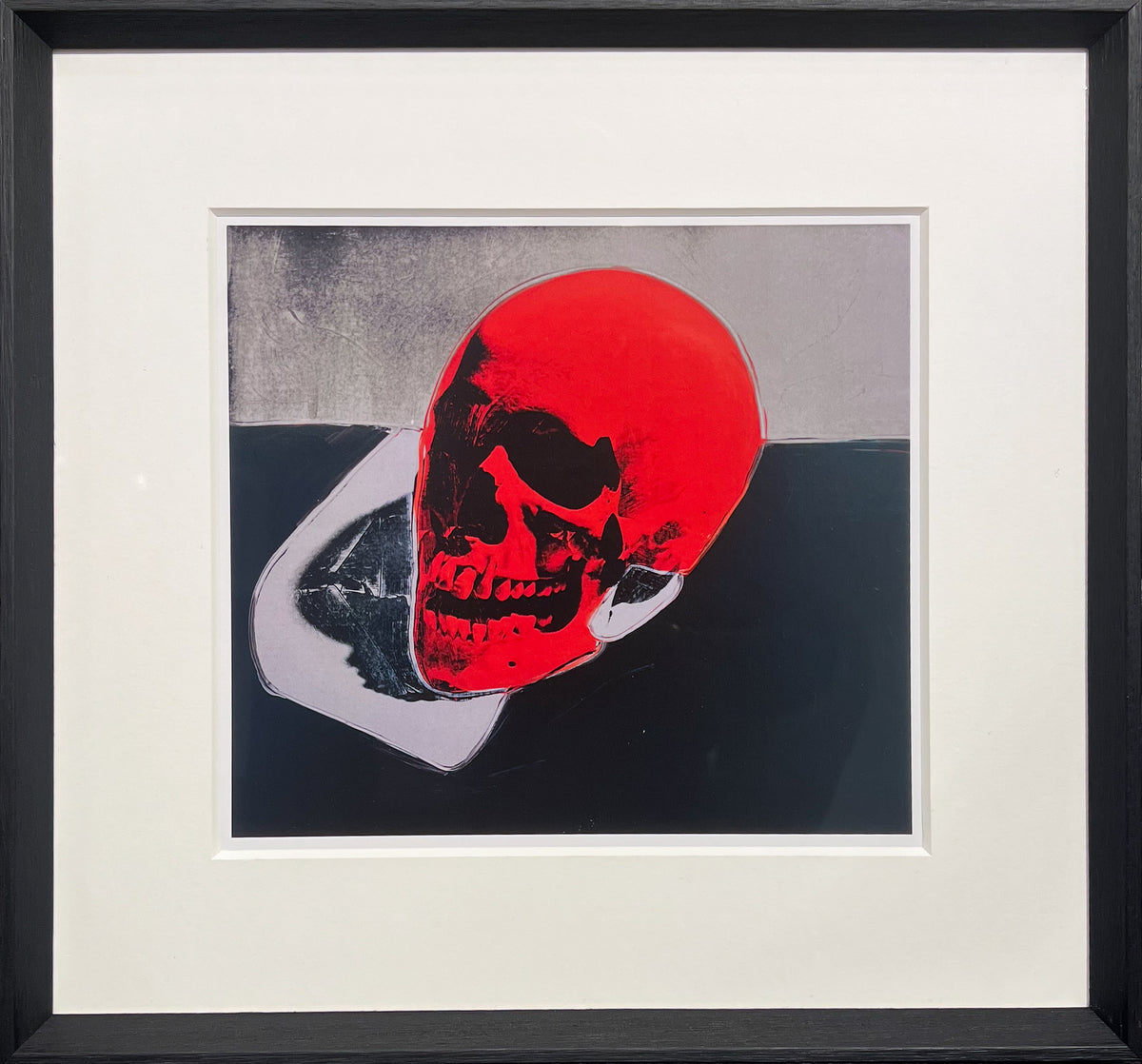 After Warhol print of a human skull rendered in flat Pop colour with a vivid red tone, from the 1976 Skulls series, framed