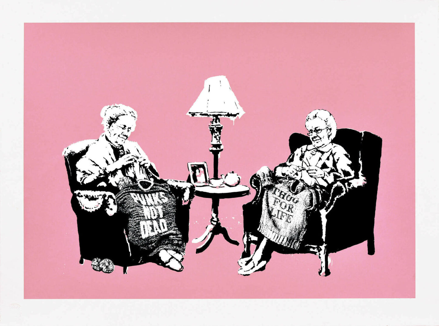 Banksy - 'Grannies' - Unsigned Silkscreen on Paper. A satirical urban artwork featuring two elderly women knitting sweaters with anti-establishment slogans against a vibrant pink background, as featured at Glastonbury 2025, available at Creed Gallery Ascot.