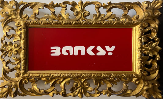 David Henty's Banksy Red: the word BANKSY spray-painted in white on a red ground in an ornate gilt frame