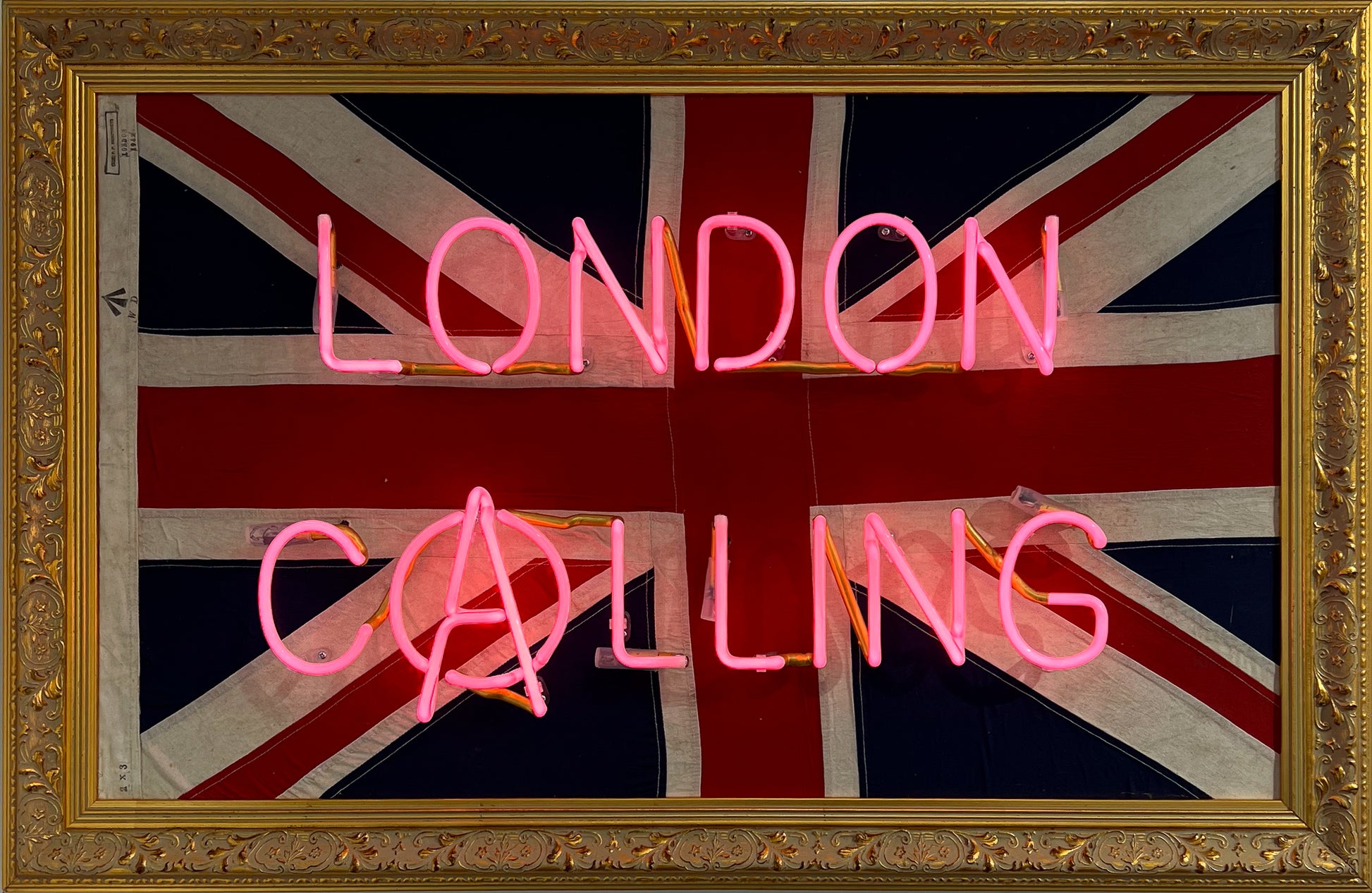 Mark Sloper "London Calling" original neon artwork shown unlit on an authentic vintage 1942 Union Jack flag. Hand-blown glass neon tubing mounted on a historical British flag, available at Creed Gallery Ascot.