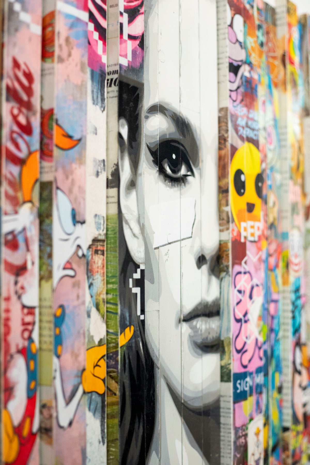 Close-up of the black-and-white face in Lhouette Misfits, with cartoon and emoji collage on the slats