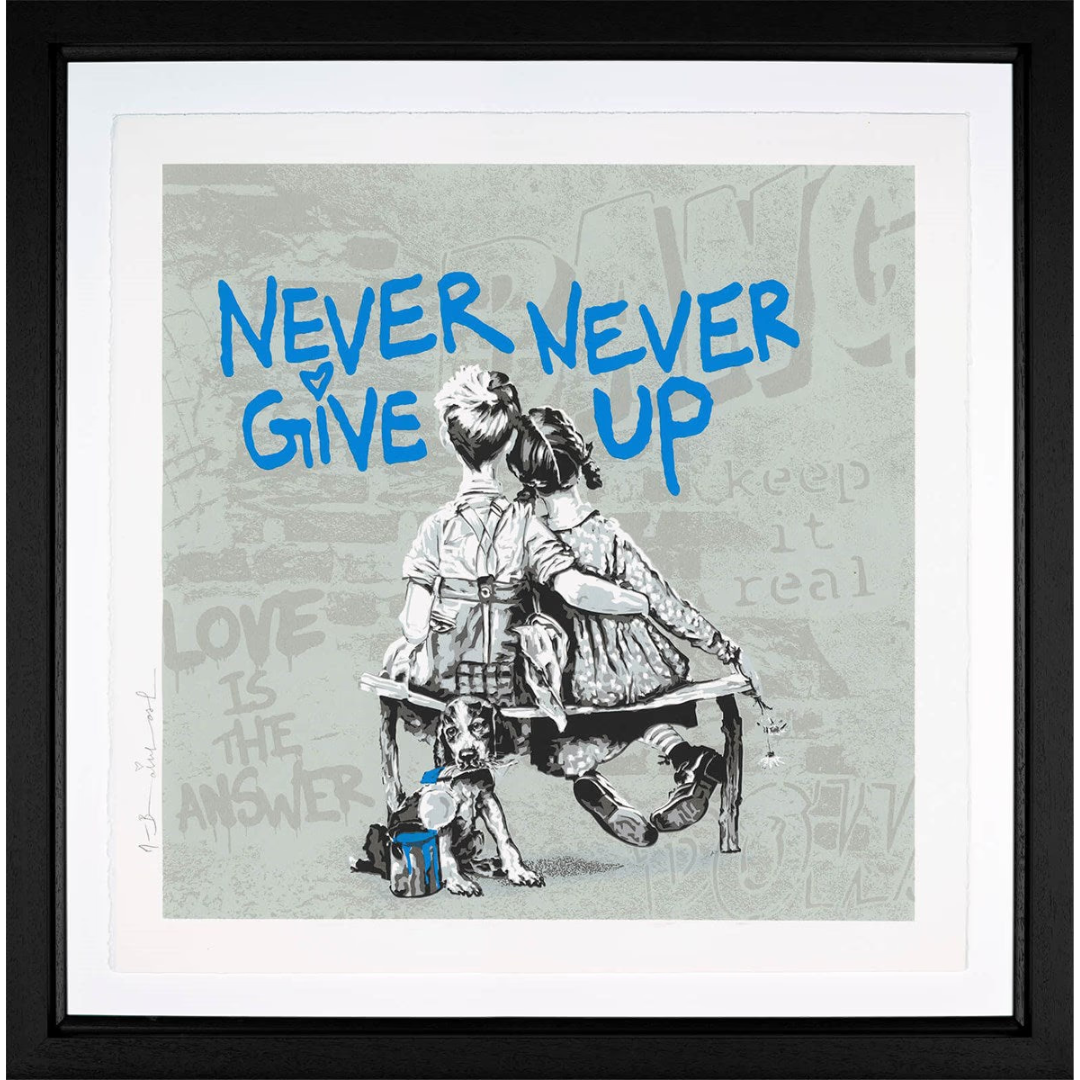 Framed contemporary artwork 'Work Well Together' by Mr. Brainwash, featuring two people on a bench, graffiti-style patterns, and 'Never Never Give Up' text in a vibrant pop art style