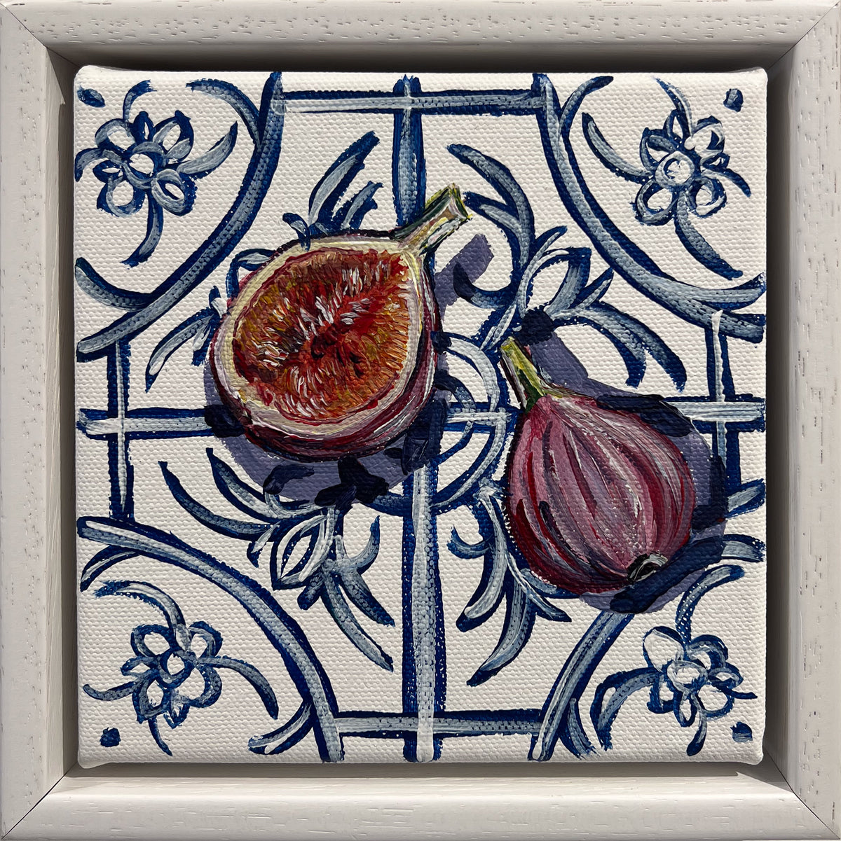 Painted still life of a halved fig and a whole purple fig on a blue and white floral tile, in a white frame
